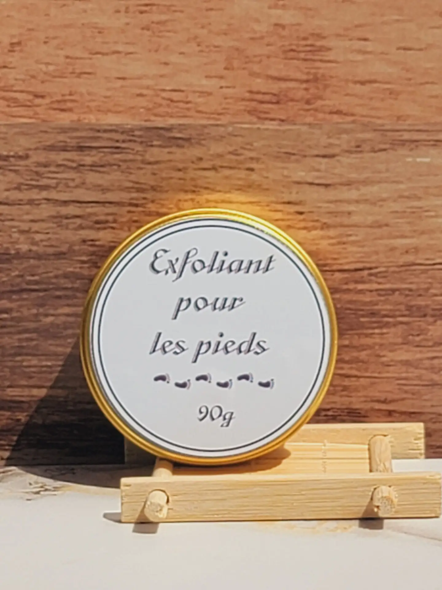 Exfoliant pour les pieds Les Mels présenté sur un fond en bois.
